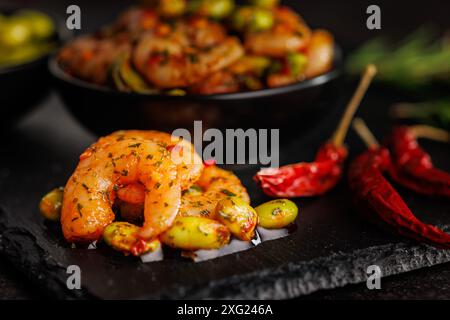 Frischer Salat mit Garnelen und Edamame Sojabohnen auf einem schwarzen Schneidebrett. Stockfoto