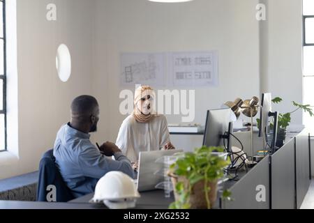 Zusammenarbeit in modernen Büros, Kollegen diskutieren Projekte am Schreibtisch mit Computern Stockfoto