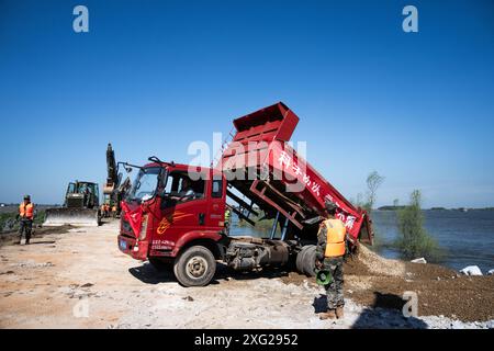 Hunan, China. Juli 2024. (240706) -- YUEYANG, 6. Juli 2024 (Xinhua) -- Retter arbeiten daran, einen Deichbruch in der Gemeinde Tuanzhou, County Huarong unter der Stadt Yueyang, zentralchinesischer Provinz Hunan, zu blockieren, 6. Juli 2024. Nach Angaben des Ministeriums für Notfallmanagement wurde ein Arbeitsteam in die zentralchinesische Provinz Hunan entsandt, um Rettungsmaßnahmen nach einem Deichbruch im zweitgrößten Süßwassersee des Landes am Freitagnachmittag zu leiten. Mehr als 800 Menschen vom chinesischen nationalen Feuerwehrteam, 146 Fahrzeuge und 82 Boote wurden nach Angaben des zum Tatort geschickt Stockfoto