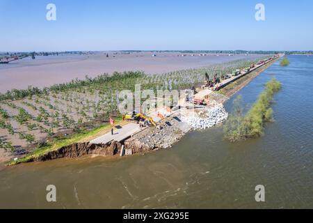 Hunan, China. Juli 2024. (240706) -- YUEYANG, 6. Juli 2024 (Xinhua) -- ein Luftdrohnenfoto vom 6. Juli 2024 zeigt Retter, die einen Deichbruch in der Gemeinde Tuanzhou, County Huarong, unter der Stadt Yueyang in der Provinz Hunan in Zentralchina blockieren. Nach Angaben des Ministeriums für Notfallmanagement wurde ein Arbeitsteam in die zentralchinesische Provinz Hunan entsandt, um Rettungsmaßnahmen nach einem Deichbruch im zweitgrößten Süßwassersee des Landes am Freitagnachmittag zu leiten. Mehr als 800 Personen des China National Comprehensive Fire and Rescue Teams, 146 Fahrzeuge und 82 Boote sind dabei Stockfoto