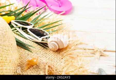 Urlaubsplanung Hintergrund von Palmblättern, Strohhut, Sonnenbrille auf weißen Dielen mit Kopierraum Stockfoto