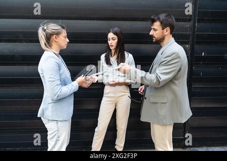 Ein Team von Geschäftsleuten, die sich vor dem Bürogebäude unterhalten. Mitarbeiterbesprechung Kurzeinweisung von Büroangestellten zu Motivationsreden für Mitarbeiter. Busi Stockfoto