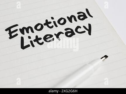 Das Wort emotionale Alphabetisierung steht auf einem Notizbuch mit Stift-Marker. Stockfoto