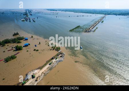 (240706) -- YUEYANG, 6. Juli 2024 (Xinhua) -- ein Luftdrohnenfoto vom 6. Juli 2024 zeigt Retter, die einen Deichbruch am Dongting Lake in Tuanzhou Township, Huarong County unter Yueyang City, Zentralchinesische Provinz Hunan blockieren. Nach Angaben des Ministeriums für Notfallmanagement wurde ein Arbeitsteam in die zentralchinesische Provinz Hunan entsandt, um Rettungsmaßnahmen nach einem Deichbruch im zweitgrößten Süßwassersee des Landes am Freitagnachmittag zu leiten. Mehr als 800 Personen des chinesischen nationalen Feuerwehrteams, 146 Fahrzeuge und 82 Boote wurden zur Scen geschickt Stockfoto