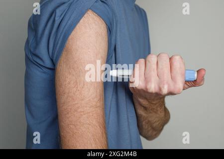 Mann, der Insulin in ihren Arm spritzt Stockfoto