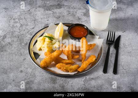 Frittierte Garnelentempura mit Kartoffelsalat auf einem Metallteller Stockfoto