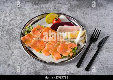 Räucherlachs mit Gemüse darunter auf einem Steintisch Stockfoto