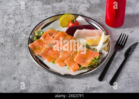 Räucherlachs mit Gemüse darunter auf einem Steintisch Stockfoto
