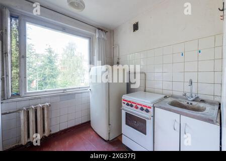 Küche in schlechtem Zustand in einem verlassenen Gebäude. Verlassenes Haus im Inneren. Dreckiges Zimmer. Altes Sowjetisches Armes Inneres. Stockfoto