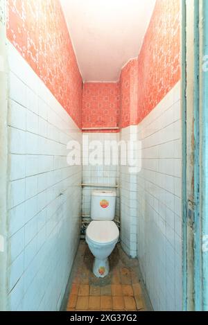 Toilette, Toilette, WC in schlechtem Zustand in einem verlassenen Gebäude. Verlassenes Haus im Inneren. Dreckiges Zimmer. Altes Sowjetisches Armes Inneres Stockfoto