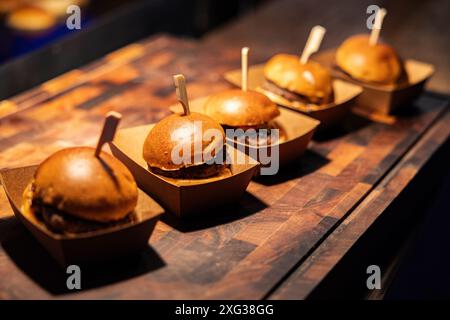 Festliches Abendessen mit leckeren Hamburger auf Holzbrettern Stockfoto