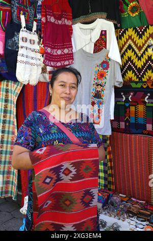 Indigene guatemaltekische Dame, die ihre farbenfrohen handgewebten Waren auf einem Backstrap-Webstuhl verkauft. In traditioneller Tracht für Santa Catarina, Lake Atitlan. Stockfoto