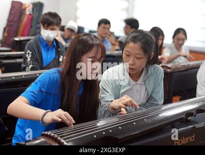 Shanghai, Shanghai Guangming High School im ostchinesischen Shanghai. Juli 2024. Schüler der New Taipei Municipal Banqiao Senior High School und der Shanghai Guangming High School versuchen, Guqin, ein gerupftes siebensaitiges traditionelles chinesisches Musikinstrument, während einer Austauschveranstaltung an der Shanghai Guangming High School im ostchinesischen Shanghai am 5. Juli 2024 zu spielen. Die Austauschveranstaltung findet vom 4. Bis 9. Juli in Shanghai statt. Quelle: Liu Ying/Xinhua/Alamy Live News Stockfoto