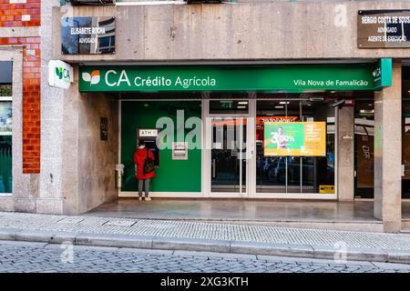 Vila Nova de Famalicao, Portugal: Bankagentur Credito Agricola. Kunde, der den Multibanco alias Geldautomaten bei einer Credito Agricola Bankagentur benutzt Stockfoto