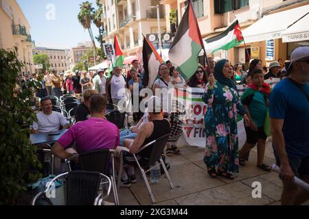 Malaga, Spanien. Juli 2024. Demonstranten werden auf einer Straße marschiert, während Touristen den Protest sehen, während sie an einer Demonstration in Solidarität mit dem palästinensischen Volk teilnehmen. Unter dem Motto "gegen den Völkermord und die zionistische Besatzung" fordern Dutzende von Menschen angesichts der anhaltenden Konflikte zwischen Israel und der Hamas ein Ende des Waffenhandels und der Handelsbeziehungen mit Israel. Quelle: SOPA Images Limited/Alamy Live News Stockfoto