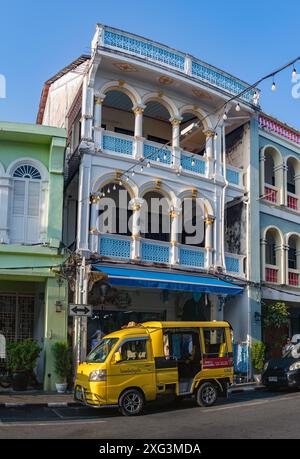 Ein Bild eines gelben Tuk Tuk vor der farbenfrohen chinesisch-portugiesischen Architektur in der Altstadt von Phuket. Stockfoto