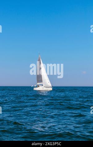 Yacht, weißes Segelboot unter Kopf genua und Hauptsegel segeln in einem ruhigen offenen Meer. Kreuzfahrt, Urlaub, Regatta, Sport. Golf von Finnland Stockfoto