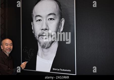 München, Deutschland. Juli 2024. Regisseur Shin'ya Tsukamoto signiert sein Porträt vor der Preisverleihung im Amerika-Haus während des Filmfestes München. Unter anderem werden internationale Filmemacher und Nachwuchstalente geehrt. Zuschauerpreise werden ebenfalls vergeben. Quelle: Felix Hörhager/dpa/Alamy Live News Stockfoto