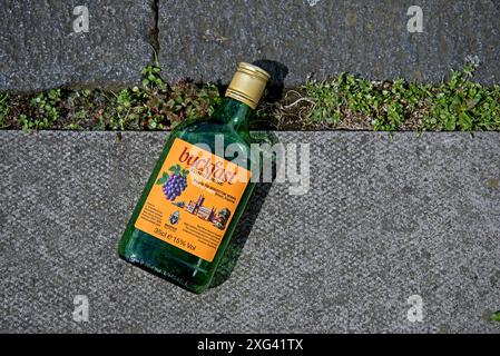 Leere halbe Flasche Buckfast Tonic Wine auf dem Bürgersteig in Edinburgh, Sotland, Großbritannien. Stockfoto