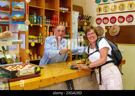 Frau, die den Jakobsweg entlang der Jakobsweg wanderte, hielt an, um in einem Geschäft in Hornillos del Camino Spanien Speisen und Getränke zu kaufen Stockfoto