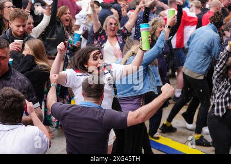 England-Fans auf dem Millennium Square in Leeds feiern, nachdem England beim Halbfinalspiel der UEFA Euro 2024 zwischen England und der Schweiz ihren Eröffnungstor erzielte. Bilddatum: Samstag, 6. Juli 2024. Siehe PA Story SOCCER England. Das Foto sollte lauten: Peter Byrne/PA Wire. EINSCHRÄNKUNGEN: Verwendung unterliegt Einschränkungen. Nur redaktionelle Verwendung, keine kommerzielle Nutzung ohne vorherige Zustimmung des Rechteinhabers. Stockfoto