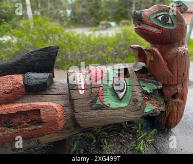 Totempfahl in Alaska muss repariert werden. Die geschnitzte Statue liegt waagerecht auf dem Boden. Holzteile sind verrottet und Farbe ist abgesplitzt. Stockfoto