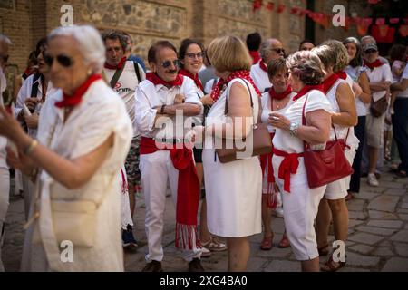 Madrid, Spanien. Juli 2024. Menschen mit roten Tüchern um den Hals warten auf ein Glas Wein, während der Feier des Beginns der San Fermin-Festlichkeiten in der Pfarrei San Fermin de los Navarros. Die Navarros-Gemeinde in Madrid feiert die San Fermin-Feierlichkeiten mit einem Raketenstart „Chupinazo“, der die Feierlichkeiten beginnt und somit zur großen Feier in Pamplona, Spanien, beiträgt. (Foto: Luis Soto/SOPA Images/SIPA USA) Credit: SIPA USA/Alamy Live News Stockfoto