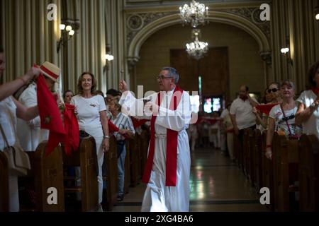 Madrid, Spanien. Juli 2024. Ein Priester segnet die roten Tücher in der Kirche während der Feier des Beginns der San Fermín-Feste in der Pfarrei San Fermín de los Navarros. Die Navarros-Gemeinde in Madrid feiert die San Fermin-Feierlichkeiten mit einem Raketenstart „Chupinazo“, der die Feierlichkeiten beginnt und somit zur großen Feier in Pamplona, Spanien, beiträgt. (Foto: Luis Soto/SOPA Images/SIPA USA) Credit: SIPA USA/Alamy Live News Stockfoto