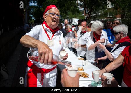 Madrid, Spanien. Juli 2024. Während der Feier zum Beginn der San Fermin-Feierlichkeiten in der Pfarrei San Fermin de los Navarros serviert ein Mann den Besuchern Wein. Die Navarros-Gemeinde in Madrid feiert die San Fermin-Feierlichkeiten mit einem Raketenstart „Chupinazo“, der die Feierlichkeiten beginnt und somit zur großen Feier in Pamplona, Spanien, beiträgt. (Foto: Luis Soto/SOPA Images/SIPA USA) Credit: SIPA USA/Alamy Live News Stockfoto