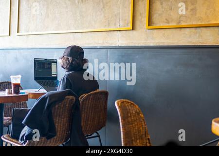 Arbeiten Sie vom Café aus. Ein Mann arbeitet an einem Laptop in einem Café Stockfoto