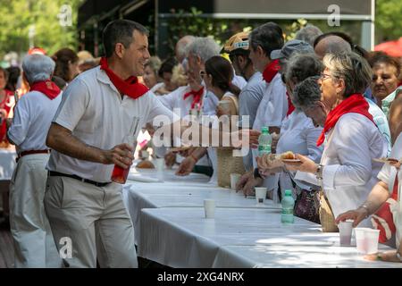 Madrid, Spanien. Juli 2024. Während der San Fermin-Feierlichkeiten serviert ein Mann Wein. Ein weiteres Jahr lang feierten die Einwohner von Navarrese in Madrid die Madrider Sanferminen in den Patios des Pfarrkomplexes San Fermín de los Navarros in Madrid. Um 11:30 Uhr wurden die Taschentücher gesegnet und um 12 Uhr, parallel zur Stadt Pamplona, wurde der Chupinazo gefeiert, der offiziell das San Fermín Festival begann. Quelle: SOPA Images Limited/Alamy Live News Stockfoto