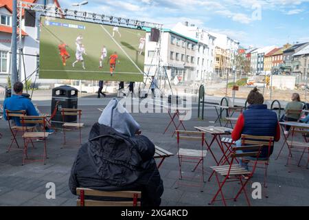 Nur sehr wenigeFußballfans verfolgen anlässlich der Fußball-Europameisterschaft UEFA EURO 2024 das Viertelfinalspiel Türkei gegen Niederland auf einer Leinwand auf dem Platz Hlemmur in Rsykajvik. / Nur sehr wenige Fußballfans sehen das Viertelfinalspiel zwischen der Türkei und den Niederlanden auf einem Bildschirm auf dem Hlemmur-Platz in Rsykajvik während der UEFA EURO 2024 Fußball-Europameisterschaft. UEFA Fußball-Europameisterschaft - Fußballfans *** nur sehr wenige Fußballfans sehen das Viertelfinalspiel zwischen der Türkei und den Niederlanden während der UEFA EURO auf dem Hlemmur-Platz in Rsykajvik Stockfoto