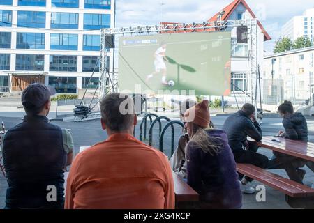 Nur sehr wenigeFußballfans verfolgen anlässlich der Fußball-Europameisterschaft UEFA EURO 2024 das Viertelfinalspiel Türkei gegen Niederland auf einer Leinwand auf dem Platz Hlemmur in Rsykajvik. / Nur sehr wenige Fußballfans sehen das Viertelfinalspiel zwischen der Türkei und den Niederlanden auf einem Bildschirm auf dem Hlemmur-Platz in Rsykajvik während der UEFA EURO 2024 Fußball-Europameisterschaft. UEFA Fußball-Europameisterschaft - Fußballfans *** nur sehr wenige Fußballfans sehen das Viertelfinalspiel zwischen der Türkei und den Niederlanden während der UEFA EURO auf dem Hlemmur-Platz in Rsykajvik Stockfoto