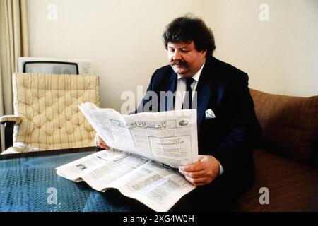 Heinz Weifenbach Praesident des Eishockeyvereins ECD Iserlohn im Januar 1988 beim Besuch in Tripolis/Libyen, liest in einer libyschen Zeitung über seinen Besuch bei Muammar Al-Ghaddafi *** Heinz Weifenbach Präsident des Eishockeyvereins ECD Iserlohn im Januar 1988 während eines Besuchs in Tripolis Libyen, liest in einer libyschen Zeitung über seinen Besuch in Muammar Al Ghaddafi Stockfoto