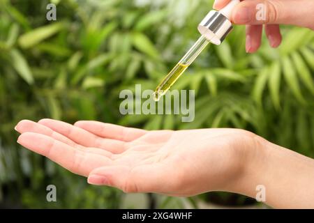 Frau tropft im Freien ätherisches Öl aus der Pipette, Nahaufnahme Stockfoto