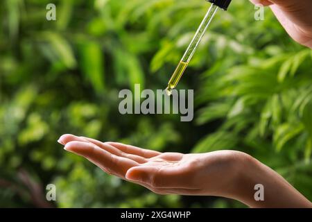 Frau tropft im Freien ätherisches Öl aus der Pipette, Nahaufnahme Stockfoto