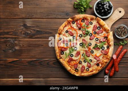 Leckere Pizza und Zutaten auf Holztisch, Blick von oben. Leerzeichen für Text Stockfoto