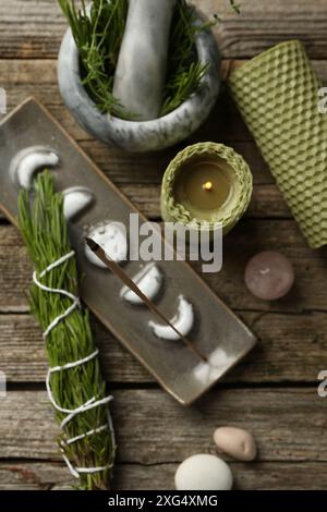 Flache Lagenkomposition mit Räucherstäbchen schwelend in Halter auf Holztisch Stockfoto