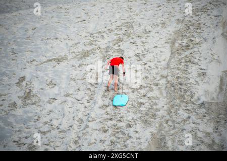 Sandboarding auf der Mangawhai Heads Beach Sanddüne - Neuseeland Stockfoto