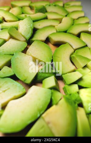 Saftige Avocadofrüchte liegen auf einem Holzbrett. Köstlicher veganischer Hintergrund Stockfoto