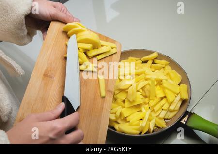 In Scheiben geschnittene Kartoffeln werden in eine Bratpfanne gelegt, Ansicht von oben Stockfoto