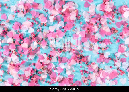 Valentinstag oder Hochzeit Hintergrund mit Papier rosa Herzen und Rosenblumen Konfetti, eine flache lag auf einem blauen Hintergrund Stockfoto