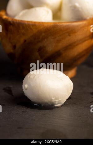 Weißkäsekugeln in einer Holzschale, Milchfutter Weichkäse in Salzlake Stockfoto