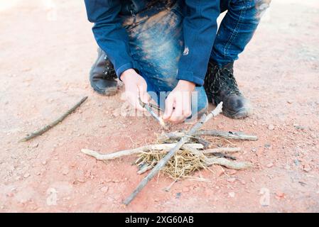 Ein Feuer mit einem Feuerstahl, Überlebens- und Abenteuerausrüstung, Outdoor-Fähigkeiten, Mann, der ein Lagerfeuer macht Stockfoto