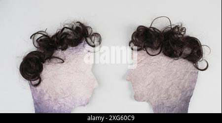 Silhouette von zwei Gesichtern mit aufeinander zuschauenden Haaren, Kommunikation, Meinungsäußerung und Diskussion, Redefreiheit, Menschen im Gespräch Stockfoto
