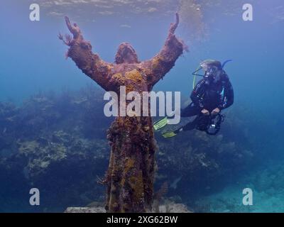 Taucher mit Kamera und Blick auf eine Unterwasserstatue von Jesus Christus (Christus des Abgrunds), Tauchplatz John Pennekamp Coral Reef State Park, Key Largo Stockfoto