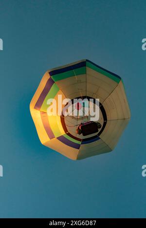 Von unten geschossen, steigt ein einzelner achteckiger Heißluftballon beim 2024 Ballons Over Waikato Festival in Hamilton auf der Nordinsel Neuseelands Stockfoto