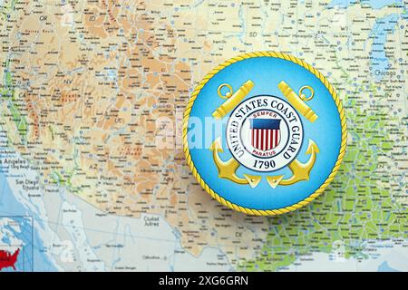 KIEW, UKRAINE - 26. JUNI 2024 Wappen der US-Küstenwache auf Papierkarte der Vereinigten Staaten von Amerika Stockfoto