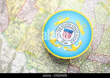 KIEW, UKRAINE - 26. JUNI 2024 Wappen der US-Küstenwache auf Papierkarte der Vereinigten Staaten von Amerika Stockfoto