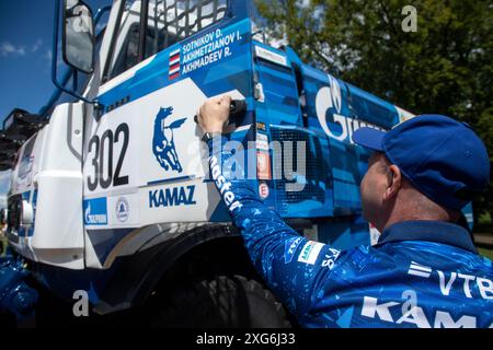 Moskau, Russland. Juli 2024. Ein Pilot des Kamaz Master Teams öffnet die Tür zu einem Cockpit des Kamaz Rallye-Trucks, der an der internationalen Seidenstraße-Rallye in Moskau teilnahm Stockfoto